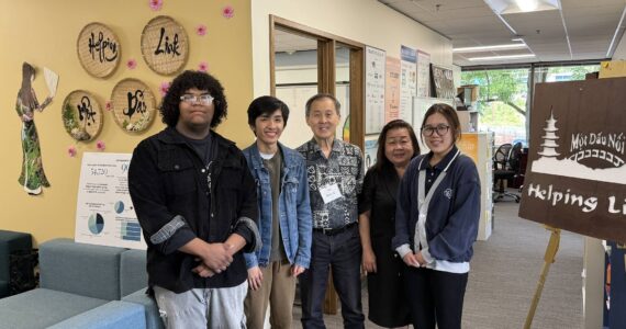Executive Director Minh-Duc Nguyen (center right) and Ron Choi (center) rely on the work of volunteers to keep Helping Link running. Photo by Drew Dotson/Sound Publishing
