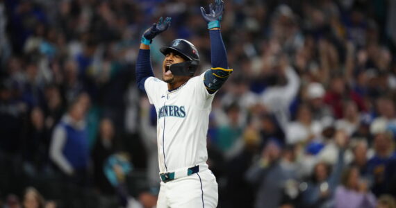 Julio Rodriguez raises his arms after scoring on a home run. Photo credit: Ben Van Houten / Seattle Mariners