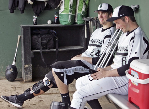 Kentwood’s Avery Kain jokes around with teammate Lucas Gately in the dugout during a game against Kentridge.
