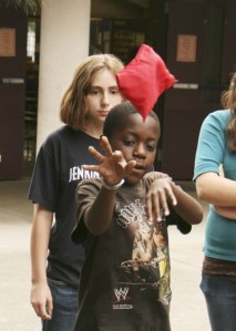 Jenay Beason looks on while Omar Abdi releases during a game of bean bag toss at the Jenkins Creek Elementary fair earlier this week.