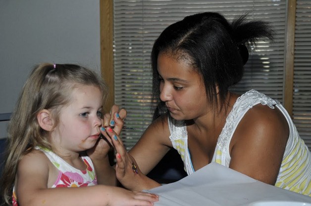 A girl gets her face painted at the National Night Out event in Black Diamond.