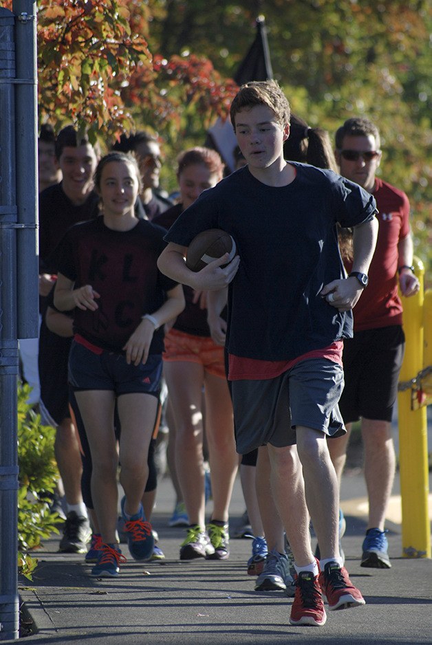 The Kentlake cross country team completed a school tradition of running the game ball for the homecoming football game from Kentlake to French Field on Friday night. Kentlake won the game against Kentridge 56-28.