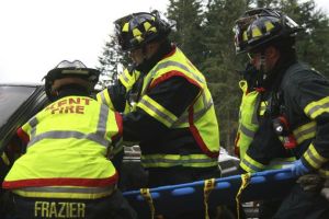 Firefighters from the Kent Fire Authority participate in a mock car crash at Tahoma High on Friday