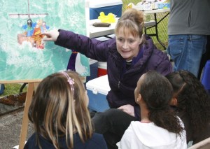 Sue Wilson tells Bible stories to three girls Saturday at the Timberlane  block party. The day included events for the families in the community.