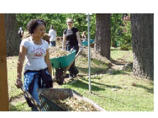 Kayla Williams is followed by Kirstin Moyers as they move woodchips into place as protective groundcover for native plants along Little Soos Creek.