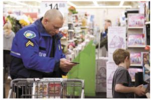 CourtSheriff deputy Jeff Harmon (left) mans a shopping cart for a young shopper.