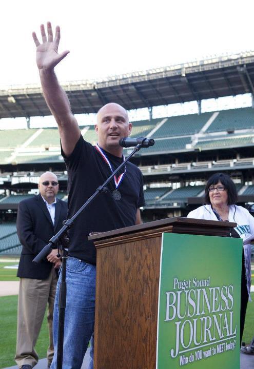 Dynamic Partners CEO Jon Botten accepts a best workplace award from the Puget Sound Business Journal at CenturyLink Field in Seattle.