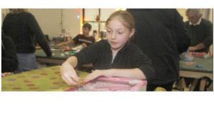 Katie Beliveau of Covington wraps one of the 350 toys donated through her school