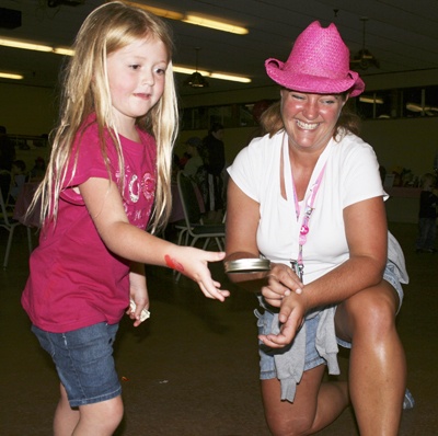Trista McDonough throws a ring at a bottle while Lisa Miller looks on during the back-to-school carnival at the Maple Valley Community Center Thursday.