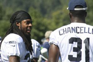 New Maple Valley resident Richard Sherman talks with a teammate at training camp on July 29.