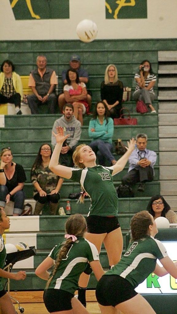 Freshman Erin Gould reaches high to hit the ball to her Kentridge opponents while Freshman Riley Sansavery (left) and Sophomore Jada Brown (right) wait for a potential tip off the block.