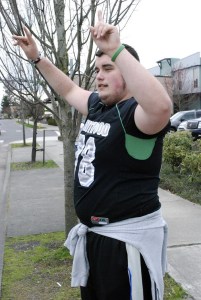 Kentwood junior Greg Tullio tries to encourage motorists on Southeast 272nd Street in Covington to stop at a fundraiser by the Conquerors football team at Jersey Mike’s on Monday. The fundraiser brought in close to $2