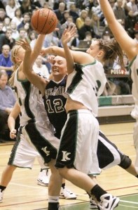 Kentwood's Courtney Johnson (left) and Jessie Genger (right) put the squeeze on Auburn Riverside's Amanda Thomson. The Conquerors knocked off the Ravens last week