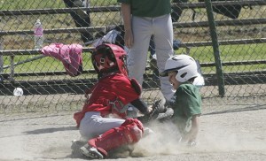 Cody Laing with the Maple Valley Bronco team slides into home Saturday at the Black Diamond Elementary School field in the game against Newcastle.