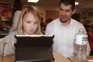 Glacier Park fifth grader Haylee Bowcut uses an Apple iPad to complete an assignment while her teacher