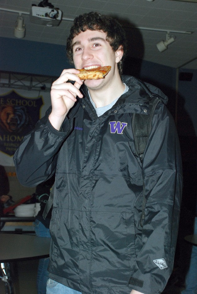 Tahoma sophomore Brooks Miller takes a bite of pizza from Garlic Jim's as part of the pre-test breakfast Wedneday morning at THS. The Tahoma PTA provided pizza