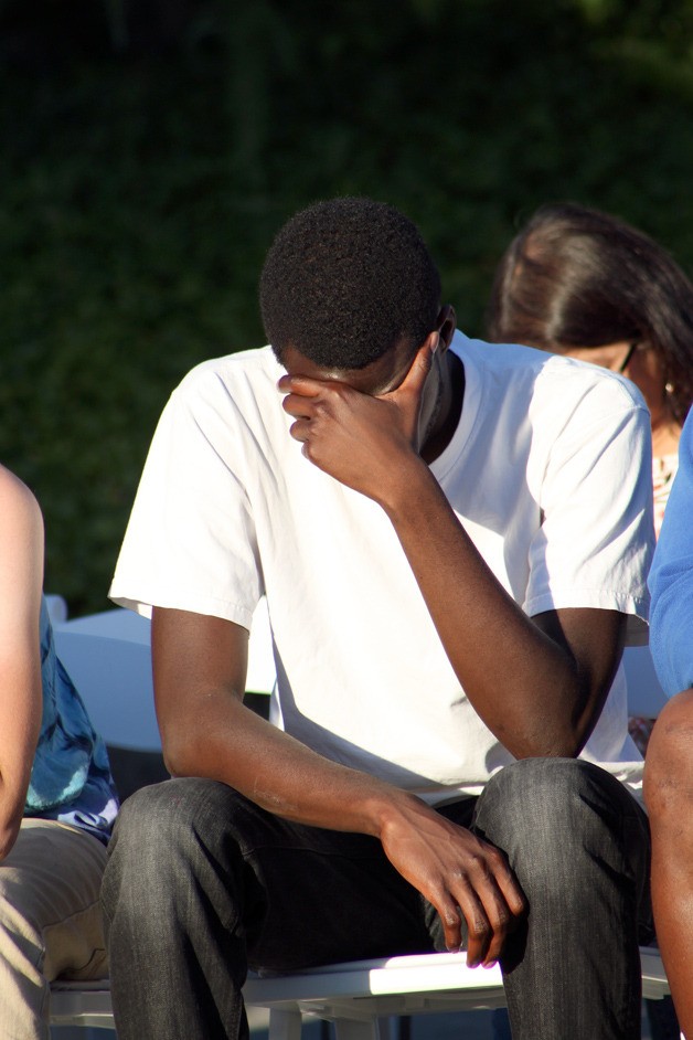 The teen’s brother bows his head during a group prayer at the gathering for his brother at New Community Church June 24. The family has requested names be kept private