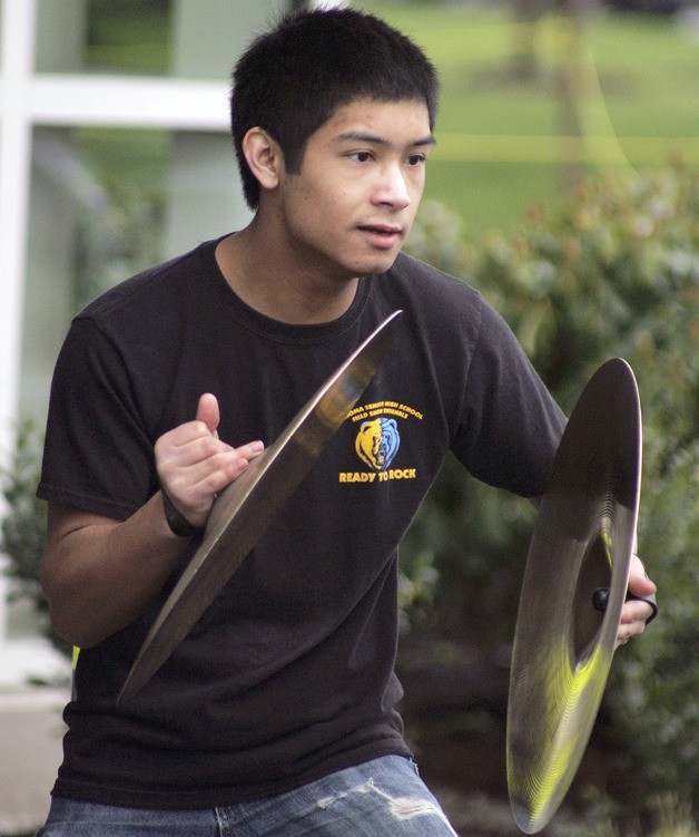 Tahoma’s Tyler Petrax holds the cymbals at the ready during the Tahoma High School marching band’s performance at the MultiCare community open house on March 31.