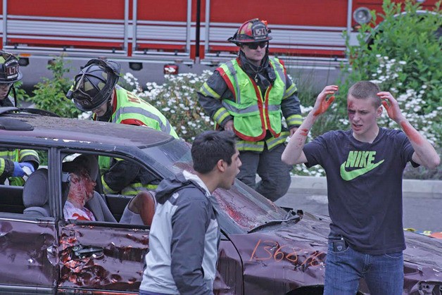 Student actors perform the aftermath of a deadly car collision May 22 as the Kent Fire Department arrive on the scene to treat the injured.