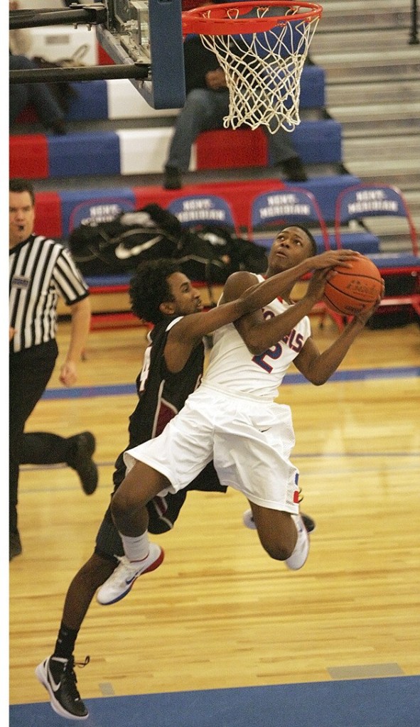 Kentlake’s Ayanle Jama tries to stop Kent-Meridian’s Mike Banks drive to the bucket in a game Dec. 16. K-M won 84-64.