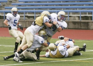 Zach Browne is tackled after a long run by Matt Stubbles and Justin Ross. Jake Akins looks on.