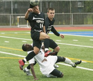 Kentwood’s Sergio Mejia heads the ball over Beamer’s Ugo Okoli and teammate Eli Peterson during Saturday’s Class 4A state quarterfinal at Federal Way Memorial Stadium.