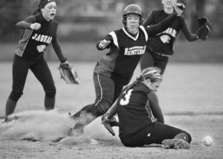 Kentlake third baseman Brooke Evans skids into second as Emerald Ridge shortstop Delsey Burgi drops the ball during a tie-breaking two-run rally Saturday at the Service Club Ballfields in Kent.