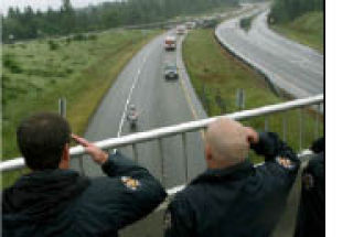 Firefighters salute from a State Route 18 overpass as a procession for firefighter Mary Hauer passes on its way to a memorial service.