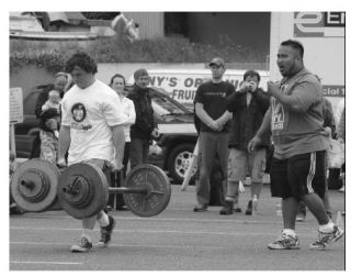 Maple Valley’s Zack Nims (left) carries 287 pounds in each hand during the Farmer’s Walk portion of “Washington’s Strongest Apple” competition held at the Des Moines Marina on June 7. Nims