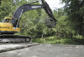 Heavy machinery digs into Kent-Black Diamond Road Wednesday as part of replacing a failing culvert beneath the roadway south of Covington.