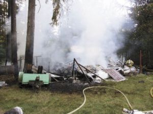 A firefighter surveys the smoking remains of a travel trailer in Covington that was destroyed by a fire early Monday evening. The fire