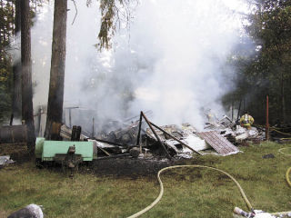 A firefighter surveys the smoking remains of a travel trailer in Covington that was destroyed by a fire early Monday evening. The fire