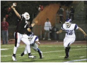 Kentlake quarterback Lewi Larson tries to get rid of the ball just before getting hit by Federal Way’s Damon Hardy (center) and Jaren Sio (right).