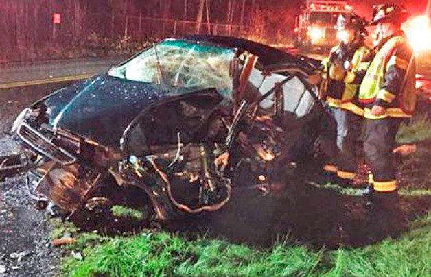 Firefighters examine one of the vehicles involved in the April accident.