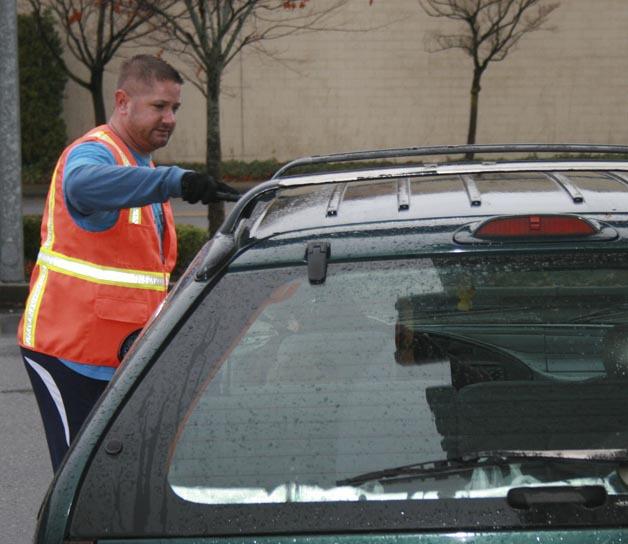 A volunteer from New Life Church's Covingt-Maple Valley location cleans the windows of a car at the Safeway gas station in Four Corners on Nov. 23. Members of the church offered single moms $20 in gas to help them get to Thanksgiving celebrations.
