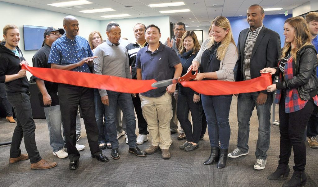 Brooke Steger, Pacific Northwest Uber general manager, joined by Uber employees and driver-partners, cuts a ribbon to mark the open of Uber&rsquo;s Greenlight Hub in Tukwila on Nov. 11. HEIDI SANDERS/Tukwila Reporter