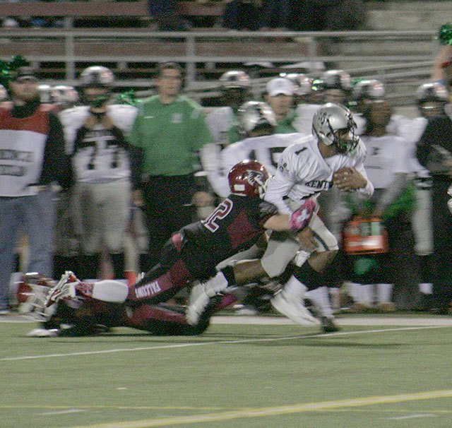 Kentwood senior Darius LuBom gets dragged down by Kentlake junior Tony Heimann II Friday at French Field. The Conks won 36-0. SARAH BRENDEN, The Reporter