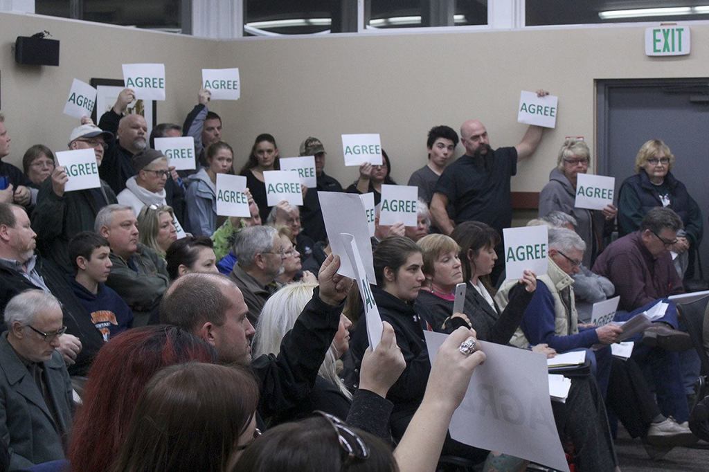 Black Diamond residents were provided with signs to indicate whether or not they agree with comments made by the city council. The majority of attendees seemed overwhelmingly in favor of the council passing Mayor Carol Benson&rsquo;s budget. Photo by Ray Still