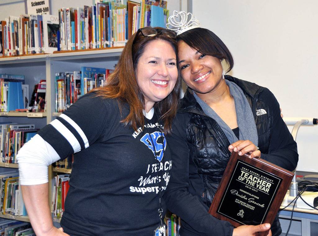 Kent Elementary Principal Rosa Villarreal, left, surprises sixth grade teacher Denisha Saucedo with a plaque naming her the Kent School District Teacher of the Year for 2017. COURTESY PHOTO, Kent School District