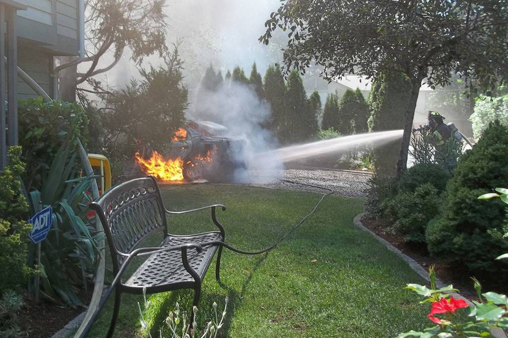 Community member Jim Flack captured Maple Valley firefighters extinguishing flames on the car. The fire from the vehicle later spread to the house. Courtesy photo