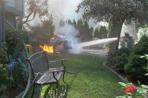 Community member Jim Flack captured Maple Valley firefighters extinguishing flames on the car. The fire from the vehicle later spread to the house. Courtesy photo
