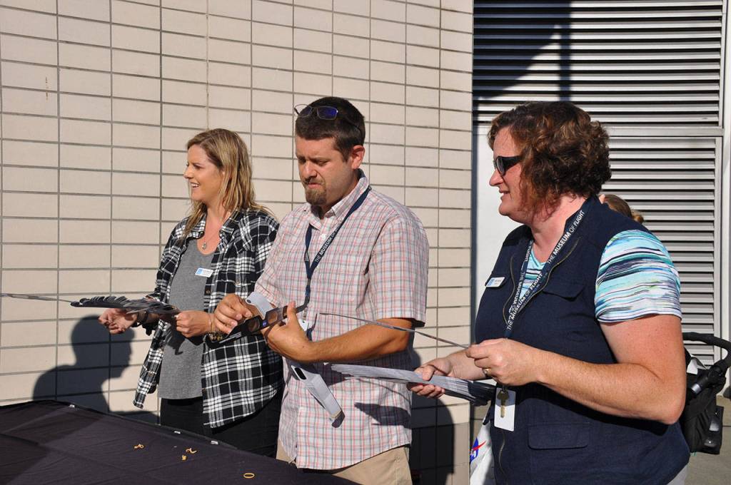 Museum of Flight staff hand out free eclipse viewing glasses. The museum of quickly ran out of the 1,000 pairs it had. HEIDI SANDERS, Reporter