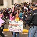 A dozen or so counter protesters included Aquila Krause, shown here speaking with a Washington State Patrol officer near the Temple of Justice at the Capitol. Photo by Taylor McAvoy, WNPA Olympia News Bureau
