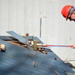 Deputy Major, Dana Parnello, slams a giant hammer into the old beach house door. Photo by Kayse Angel