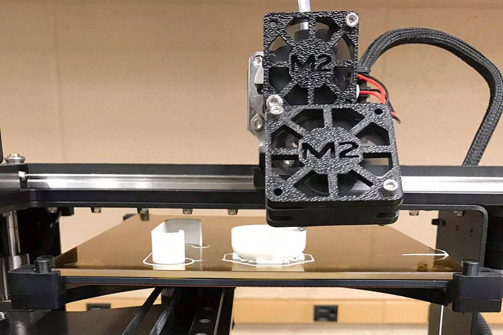 The 3D printer that is used in the engineering class at Kentwood prints out the hopefully last prototype for Sean Larue and his partners project that they made for their client who had a stroke. Photo by Kayse Angel