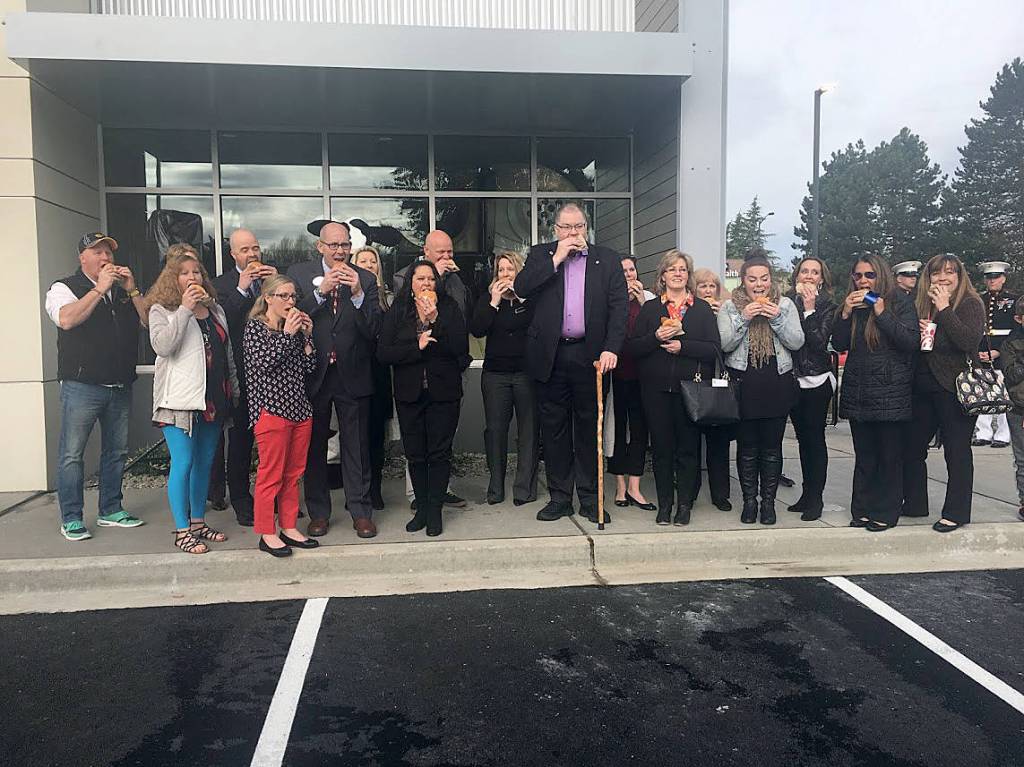 Marc Schuh, owner of the Covington Chick-fil-A, along with his wife, Covington Mayor Jeff Wagner and Covington Chamber of Commerce members take part in a ceremonial first bite during the April 12 grand opening event. Photo by Sarah Brenden