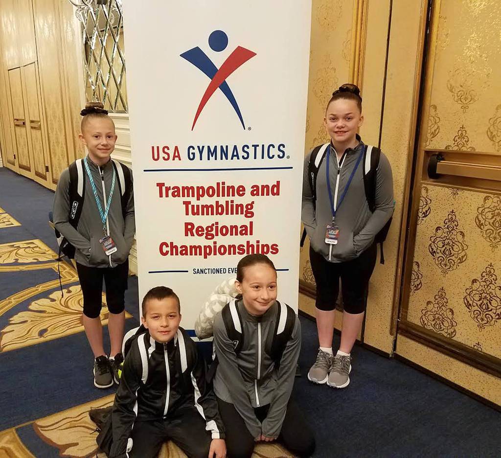 Gymnasts from Summit Gymnastics pose in front of a regionals sign to capture the memory of being there. Submitted photo
