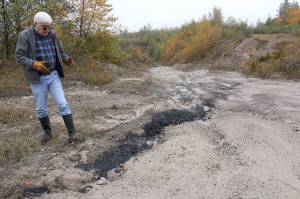 Pacific Coast Coal Company geologist Mike Conaboy shows off a small seam of coal on the surface close to Pit 2, where the company will be mining coal. Photo by Ray Still