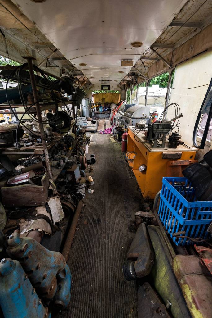 The interior of one of the several buses found on Pillons property. The buses in the illegal junkyard are often used as storage for other artifacts found in the rubble. Photo by Caean Couto