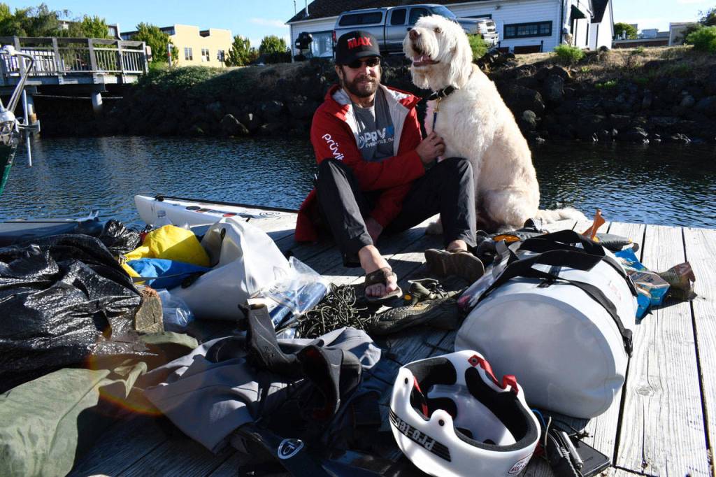 R2AK entrant Josh Collins of Merritt Island, Fla., is Team Torrant, a stand-up paddleboarder who plans to go all the way to Ketchikan while raising awareness of traumatic brain injuries and PTSD in veterans. Collins is with his therapy dog Charlie who wont be going along for the ride. The race begins Thursday at 5 a.m. from the Port Townsend waterfront. (Jeannie McMacken/Peninsula Daily News)